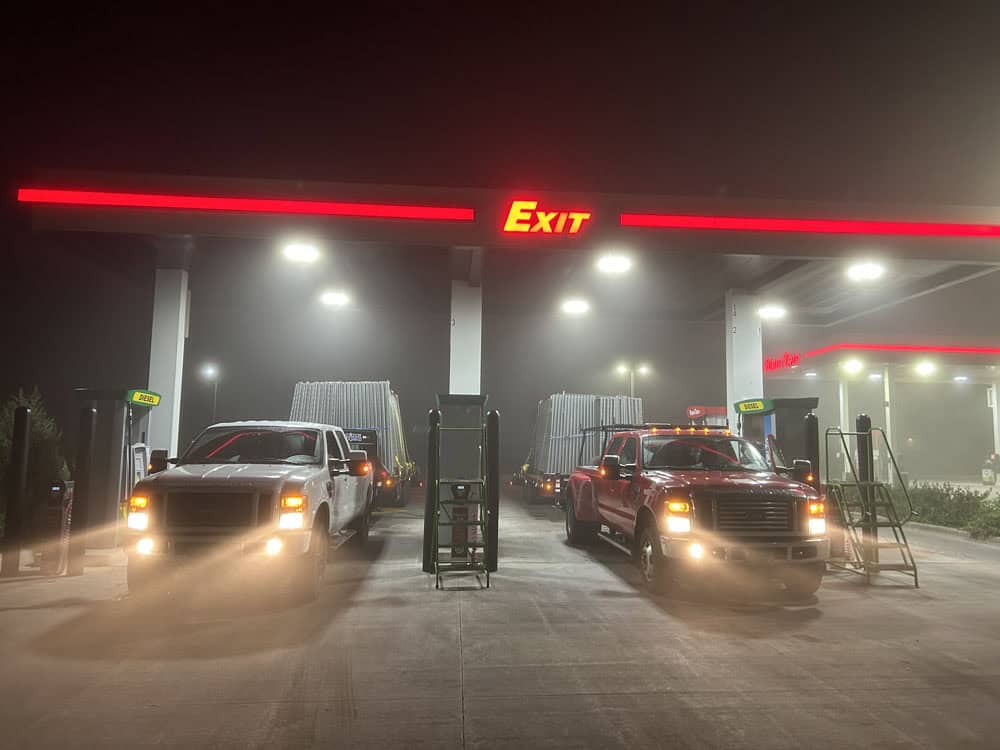 Flyway Fence Co trucks loaded up with temporary fencing and gassing up with fuel