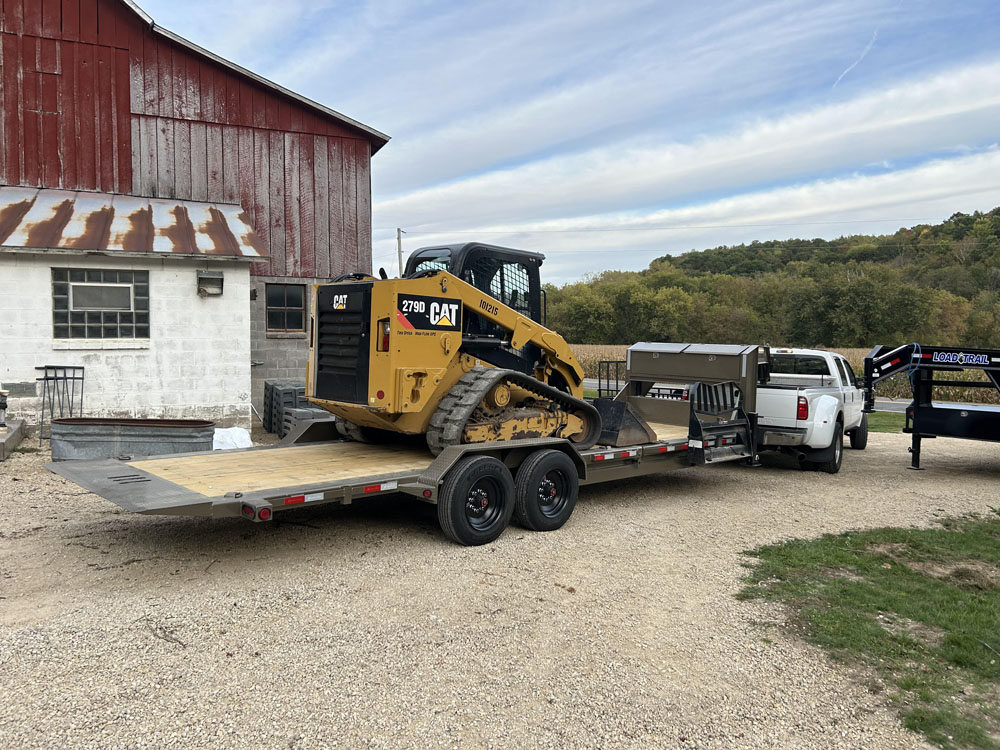 Skid steer loaded up on Flyway Fence Co trailer