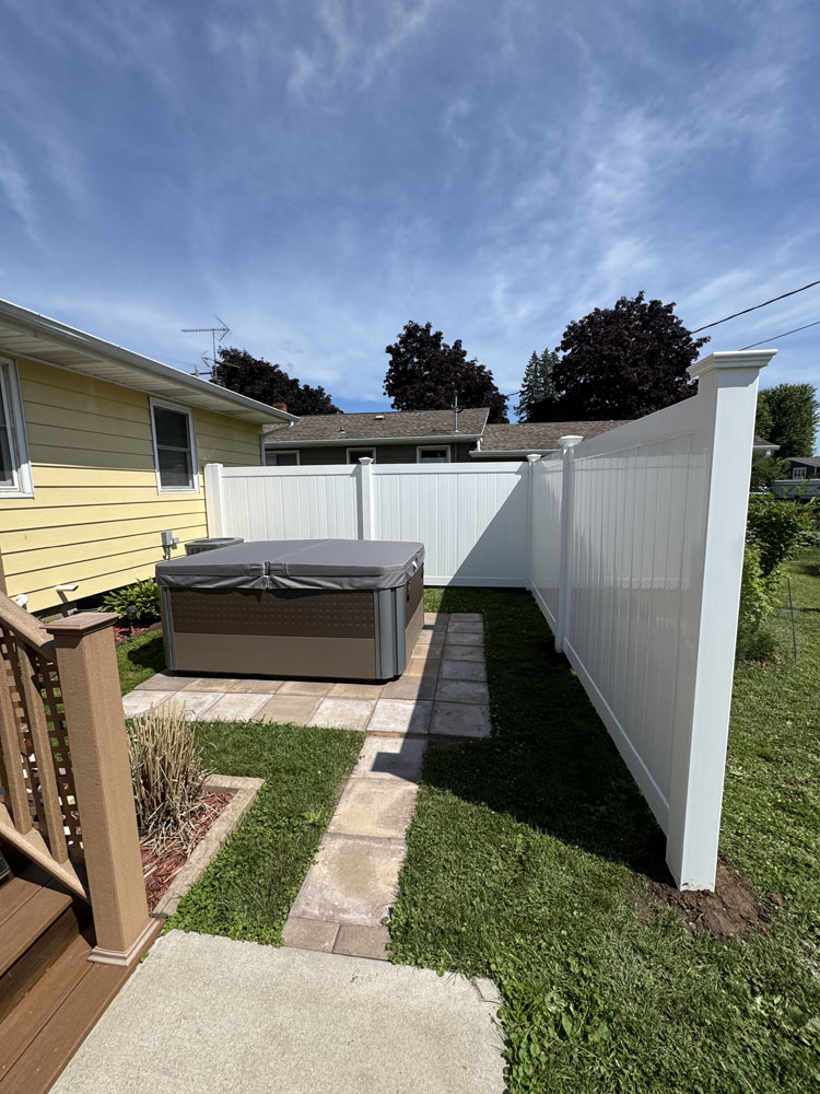 White Vinyl Fence installed next to a yellow home