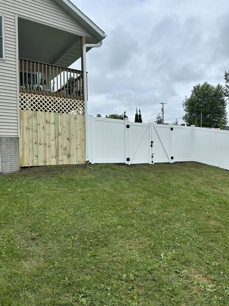 white vinyl fence installed next to wood fence